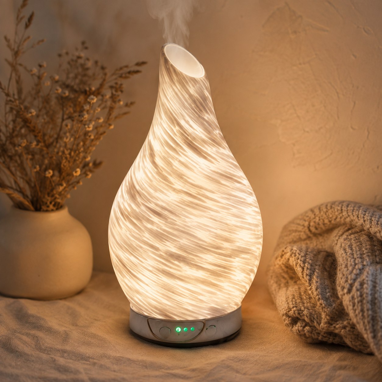 Lit white and gold glitter aroma humidifier diffuser releasing a soft plume of scented mist, glowing warmly in a dark room