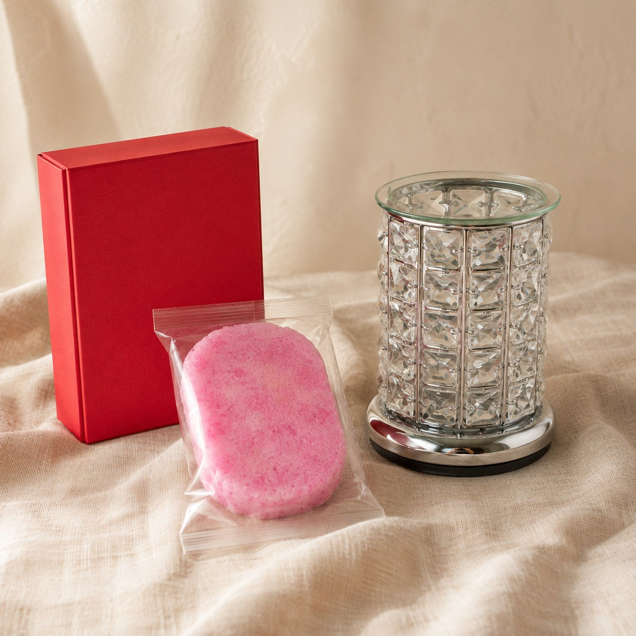 Red gift box with a silver crystal electric wax melt burner and a pink exfoliating soap sponge