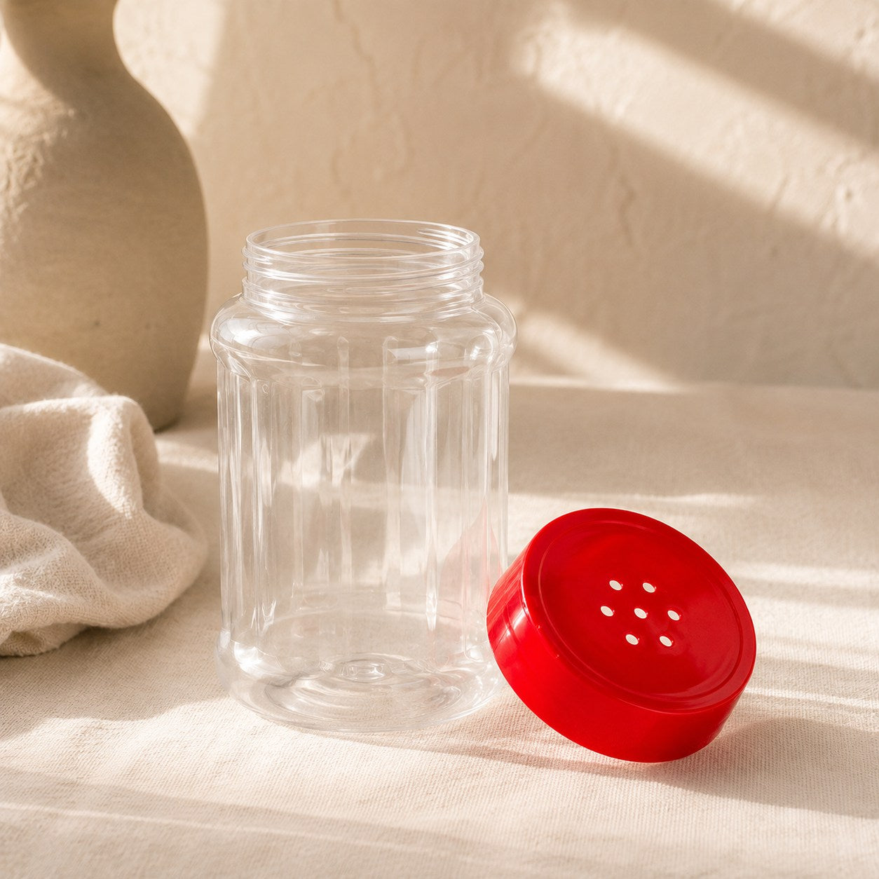 Empty refillable shaker bottle with red perforated shaker lid