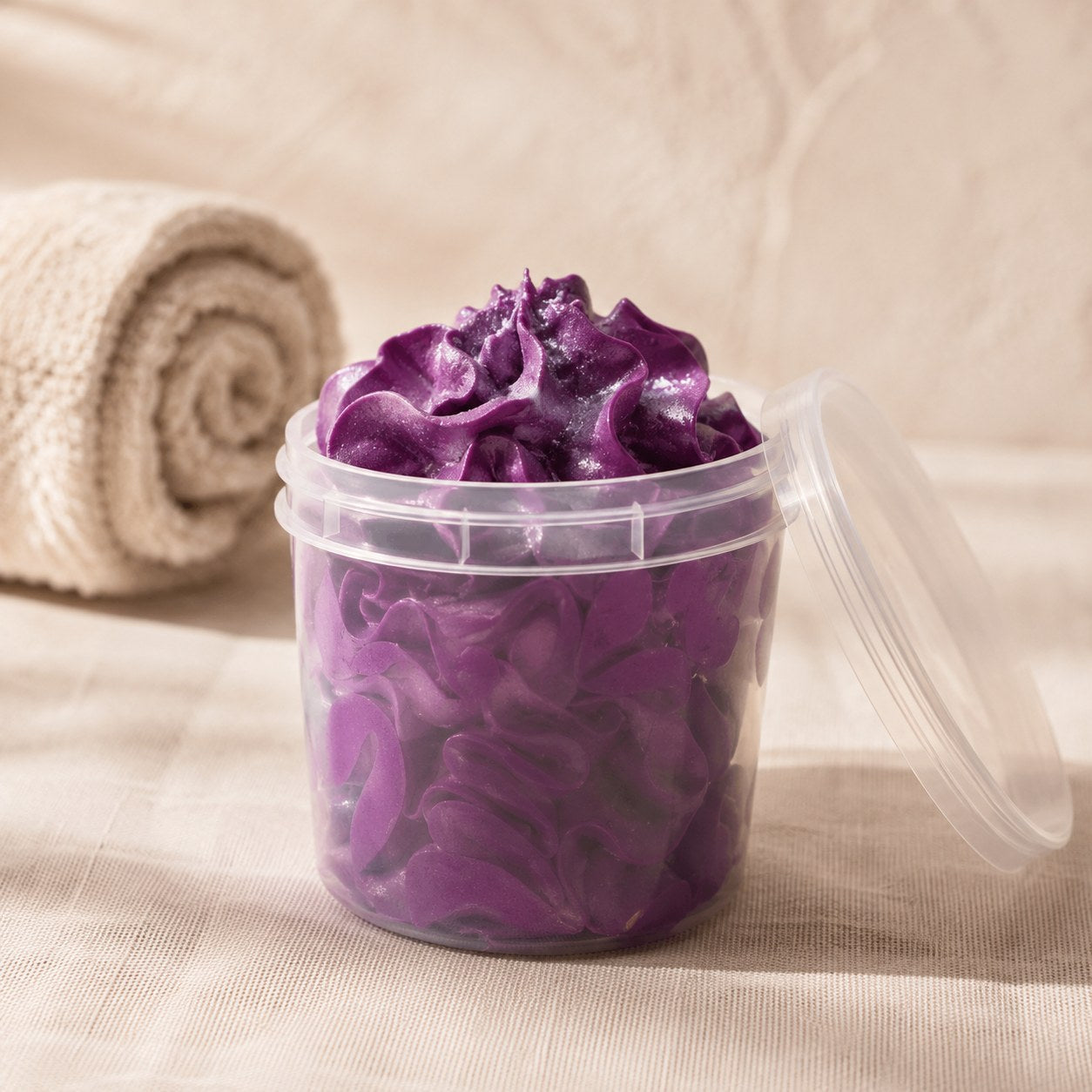 Whipped soap piped into a clear tub in deep purple